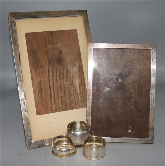 Two silver photograph frames and three silver napkin rings.